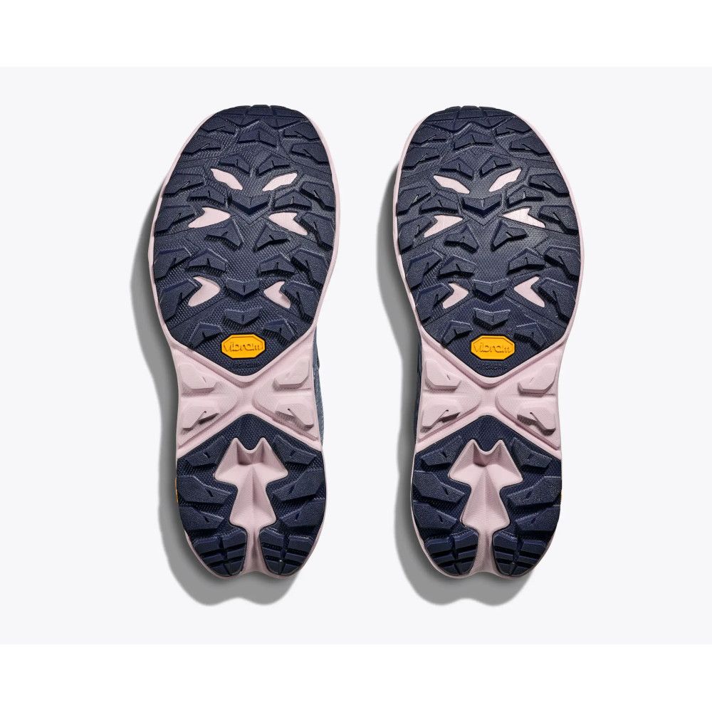 Bottom view of two navy and pink athletic shoes with rugged, multi-directional outsoles showing deep tread patterns