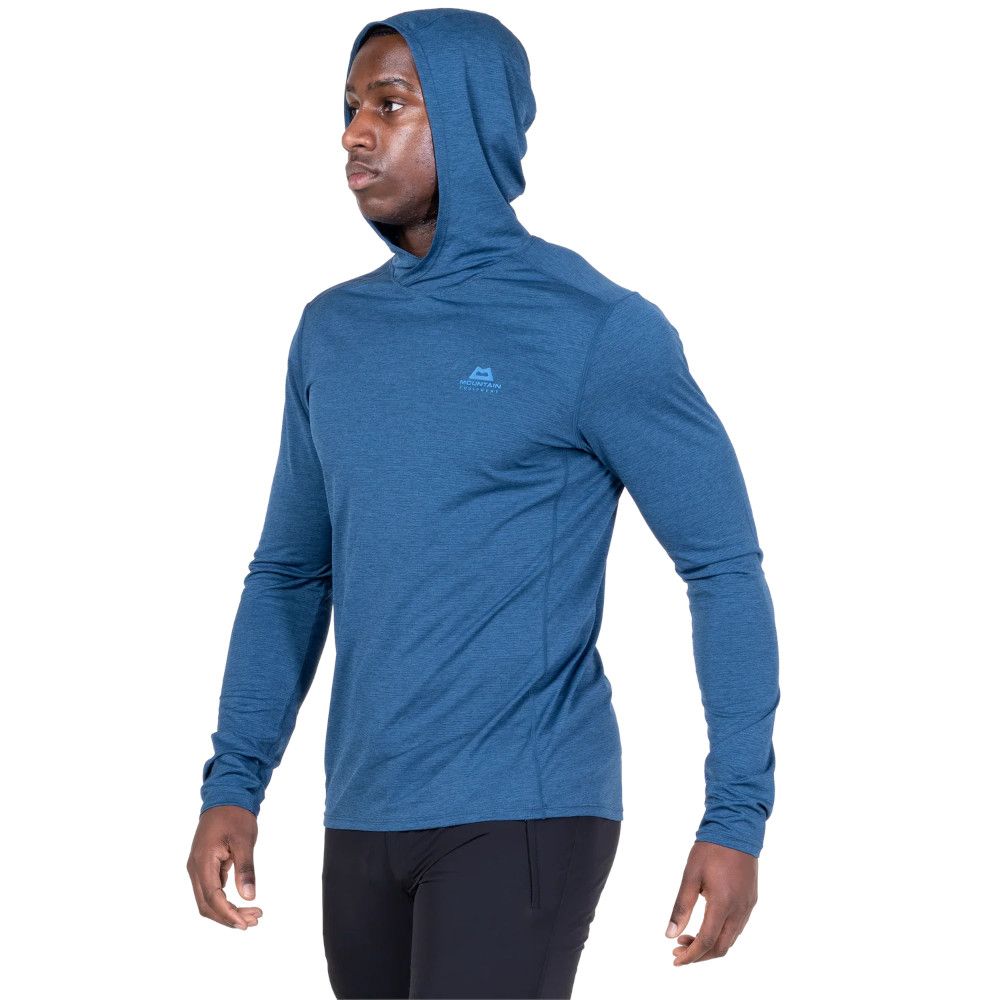 Male model wearing a blue hooded athletic shirt with logo on the chest, facing left in profile.