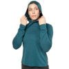Woman in teal hoodie adjusts the drawstrings at the hood, looking off to the side.