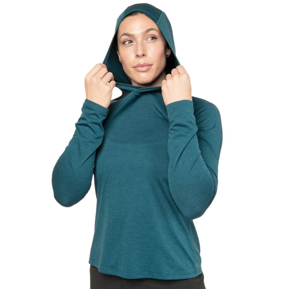 Woman in teal hoodie adjusts the drawstrings at the hood, looking off to the side.