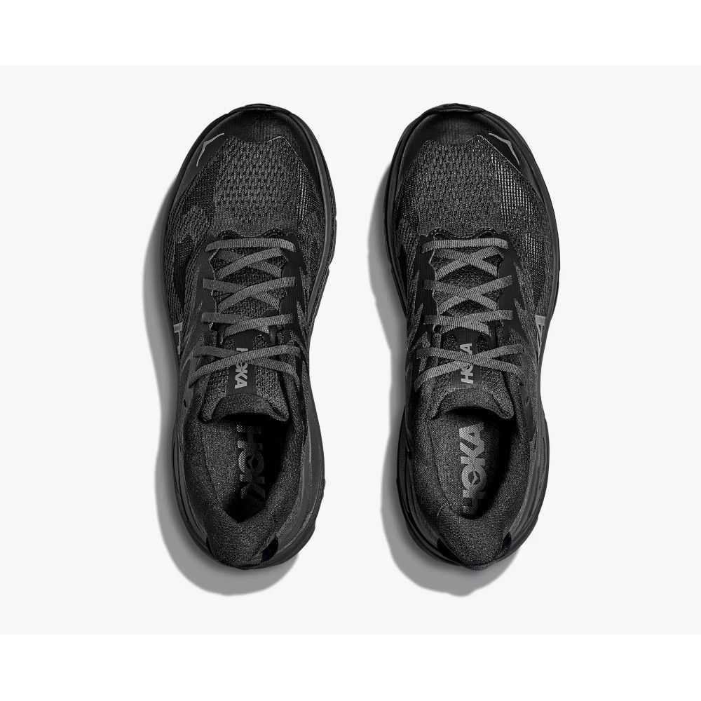 1_43c614ff-305c-487c-b528-744a22aa94cf Top-down view of a pair of black running shoes placed side by side on a light background, laces tied.