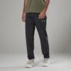 Man wearing dark gray cargo pants with a small logo on the thigh, olive shirt, and light sneakers in a studio setting.