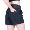 1_43c614ff-305c-487c-b528-744a22aa94cf Side view of a person wearing dark athletic shorts with an elastic waistband; their hand rests in a side pocket at the hip.