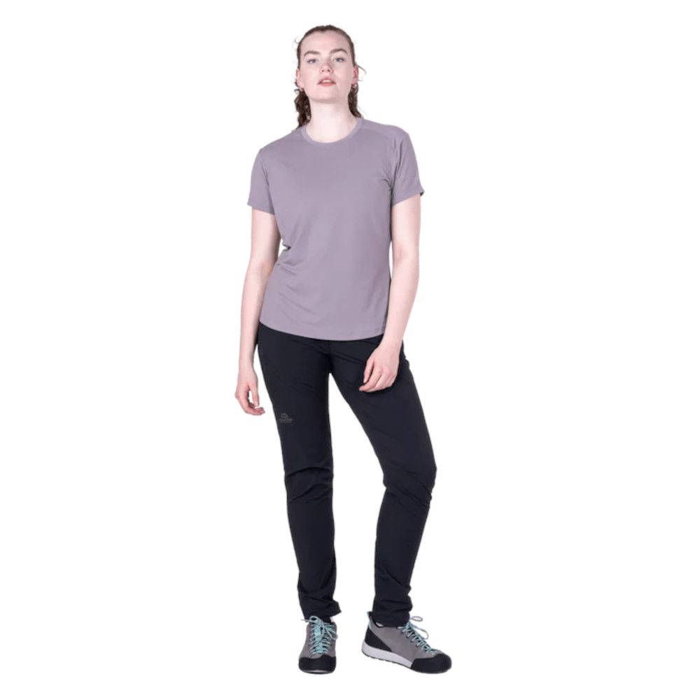 1_43c614ff-305c-487c-b528-744a22aa94cf Woman modeling a lavender short-sleeve T-shirt and black athletic pants with teal-lace sneakers, standing pose.