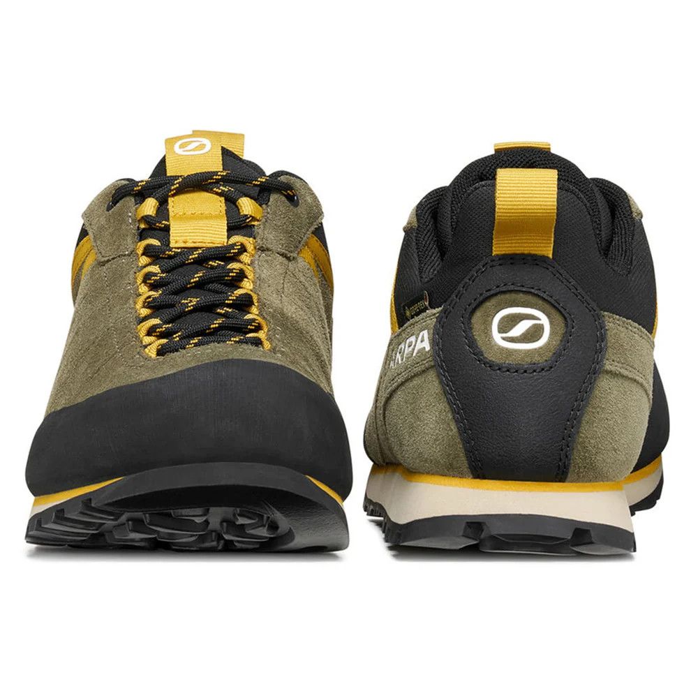 Olive and black outdoor hiking shoes with yellow laces and pull tabs, shown from the front and rear to highlight design and grip.