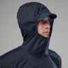 1_43c614ff-305c-487c-b528-744a22aa94cf Person wearing a navy windbreaker with hood and cap, facing right in a profile view.