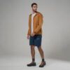 1_43c614ff-305c-487c-b528-744a22aa94cf Man wearing a tan lightweight windbreaker over a white T-shirt, navy shorts, dark socks, and orange-laced hiking shoes, posing in a studio.
