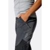 1_43c614ff-305c-487c-b528-744a22aa94cf Close-up of a person wearing gray athletic top and dark hiking pants with a zip pocket and Rab logo on the thigh