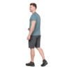 1_43c614ff-305c-487c-b528-744a22aa94cf Side view of a man in a teal T-shirt and dark shorts walking, wearing black trail shoes with orange laces