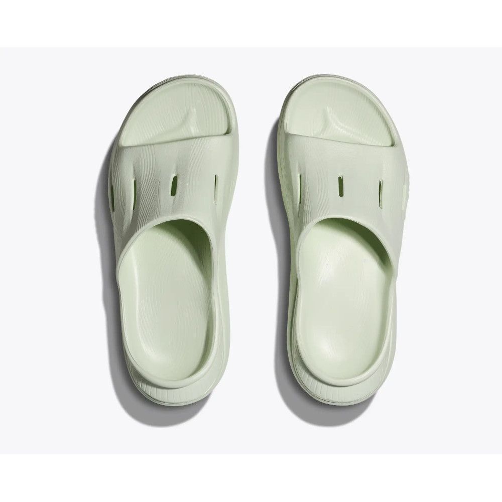 Mint green slip-on clogs (Crocs-style) viewed from above, two shoes side by side.