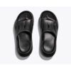 Pair of black slide sandals viewed from above on a light background, showing open-toe design and textured footbeds.