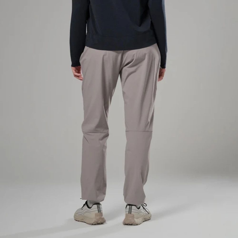 1_43c614ff-305c-487c-b528-744a22aa94cf Back view of a person wearing light gray loose-fit pants and white sneakers against a neutral backdrop