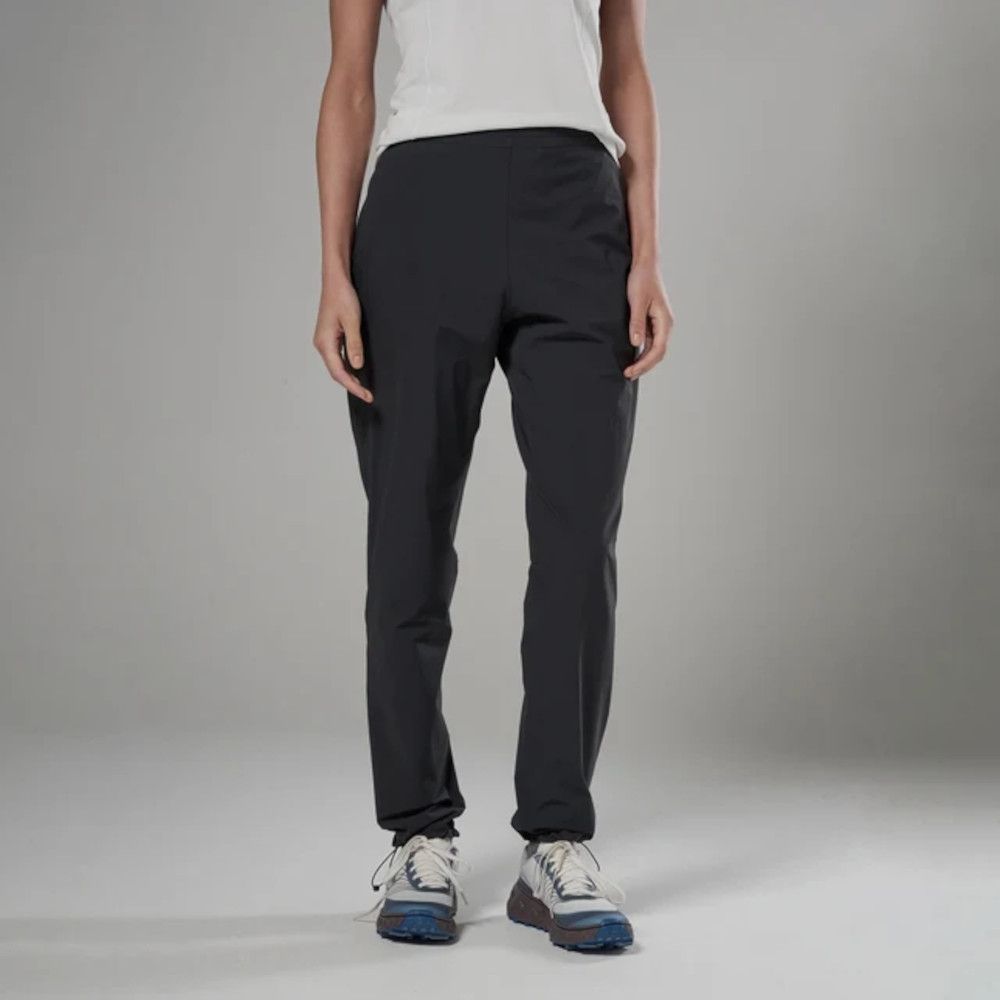1_43c614ff-305c-487c-b528-744a22aa94cf Full-length view of a person wearing charcoal hiking pants, a white top, and blue-and-white sneakers, standing against a neutral backdrop.