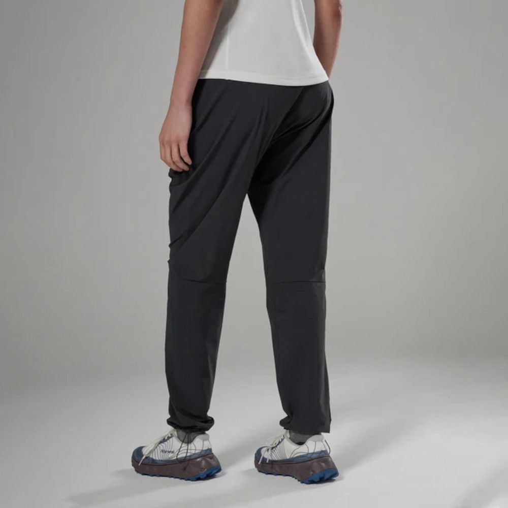 1_43c614ff-305c-487c-b528-744a22aa94cf Back view of a person wearing dark gray athletic joggers with cuffed ankles and white top in a neutral studio setting.