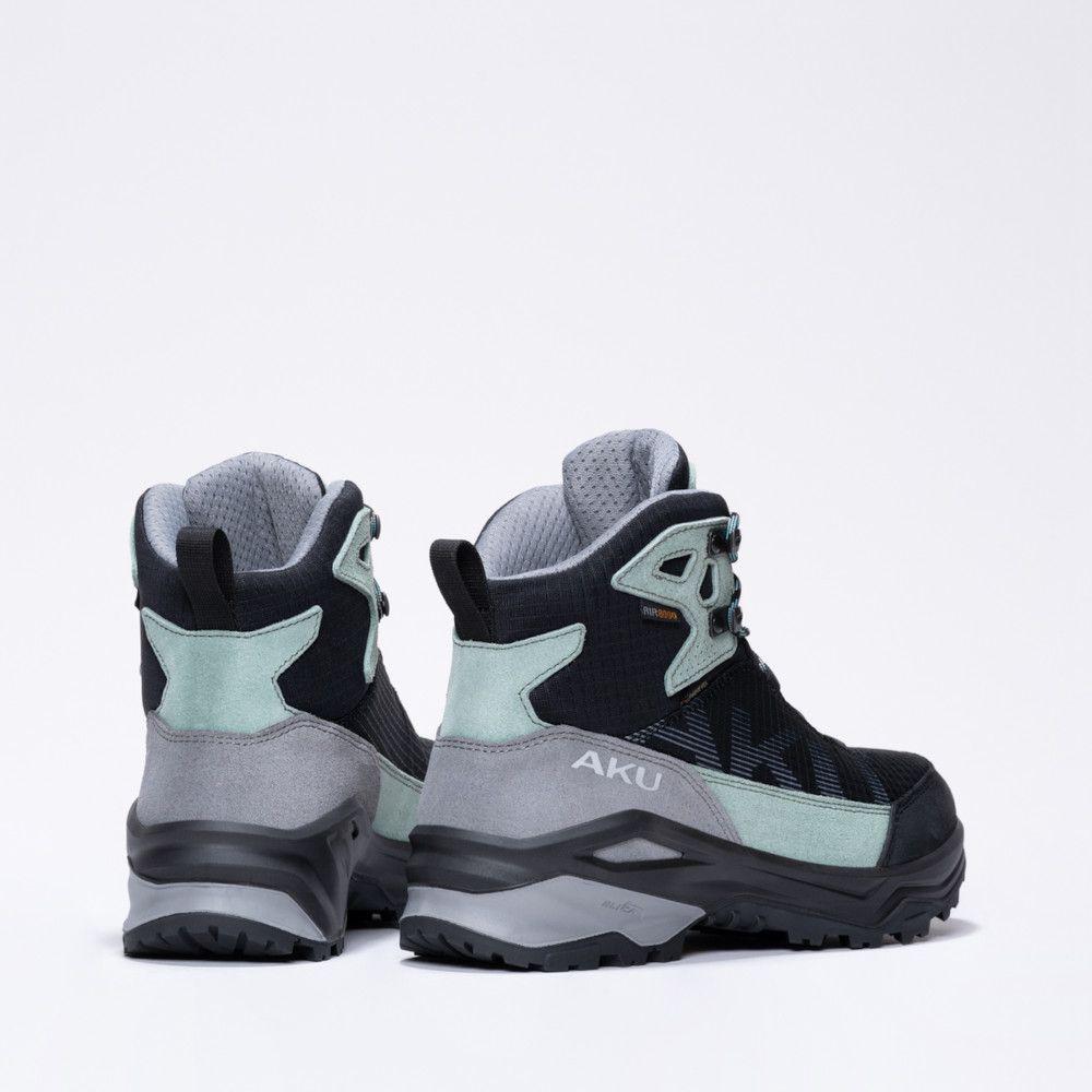 Back view of two black and mint-green hiking boots with gray midsoles and rugged soles, AKU branding visible on the side.