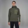 Man wearing an olive green hooded outdoor jacket, facing camera in a studio.