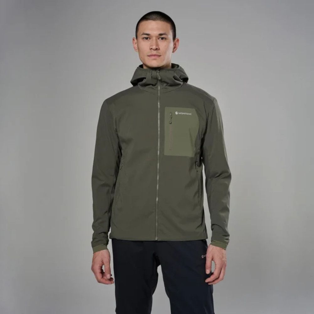 Man wearing an olive green hooded outdoor jacket, facing camera in a studio.