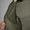 Close-up of a person opening a green jacket to reveal a soft, textured olive lining.