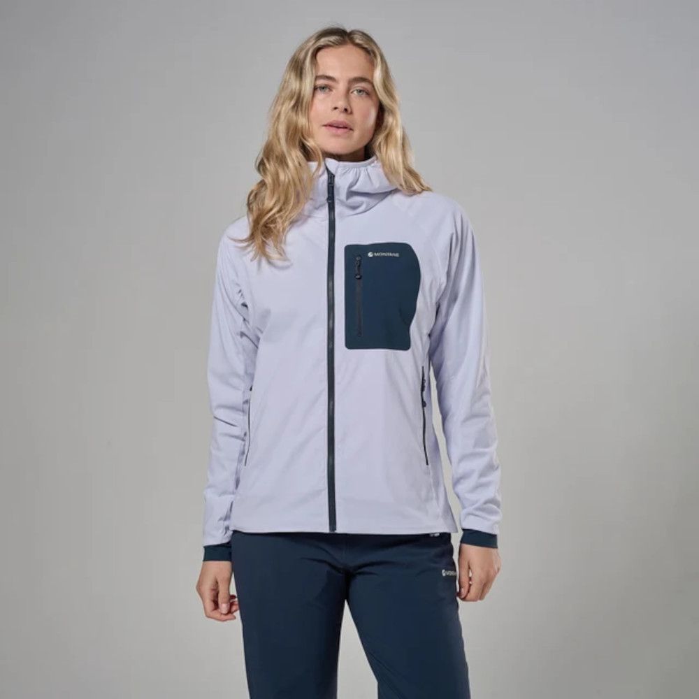 1_43c614ff-305c-487c-b528-744a22aa94cf Woman wearing a light-gray zip-up soft-shell jacket with a dark blue chest pocket and navy pants, posing against a neutral backdrop.