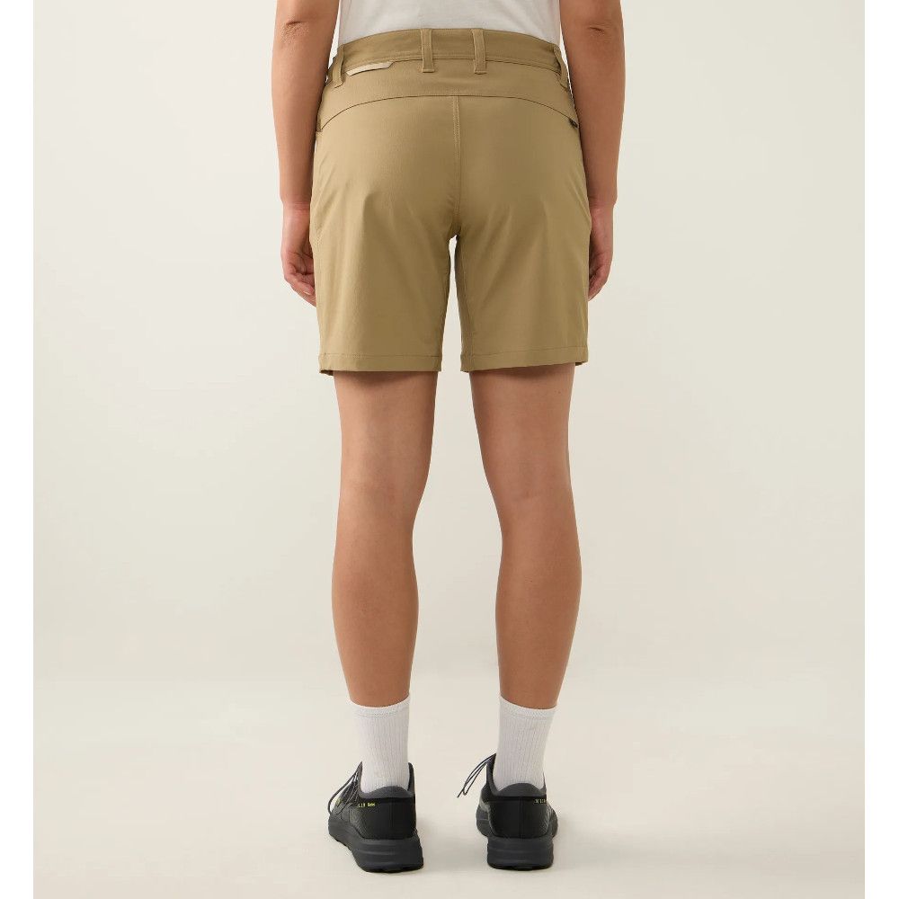 Back view of a person wearing tan chino shorts, white socks, and black sneakers.