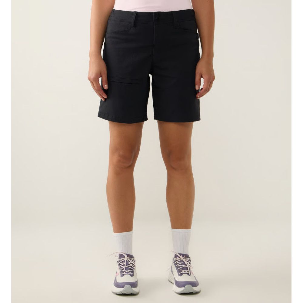 Model wearing black knee-length walking shorts, pink top, white socks, and purple athletic sneakers; front view.