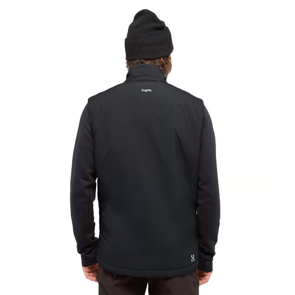 Back view of a person wearing a black Haglöfs jacket and a dark knit beanie, shown from behind.