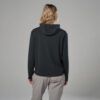 Back view of a person wearing a black hoodie and light gray pants against a neutral gray background.