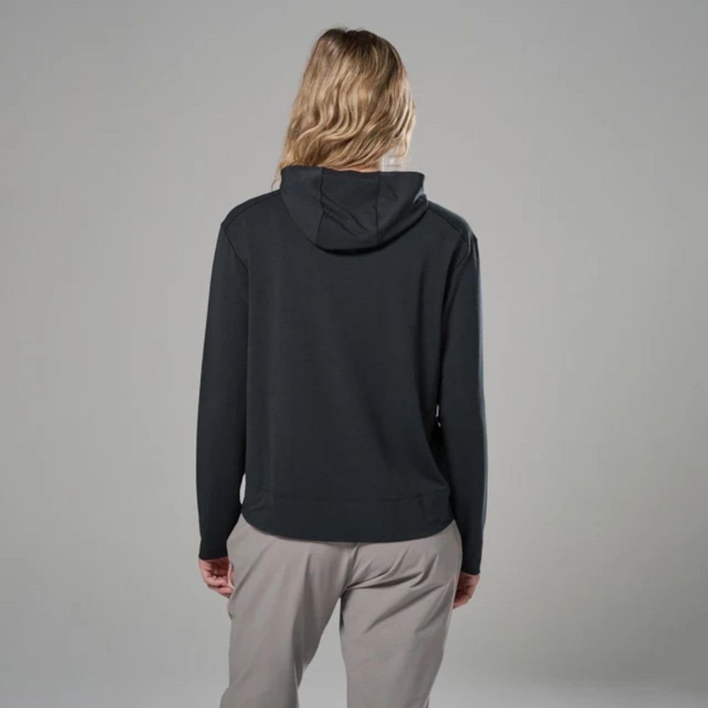 Back view of a person wearing a black hoodie and light gray pants against a neutral gray background.