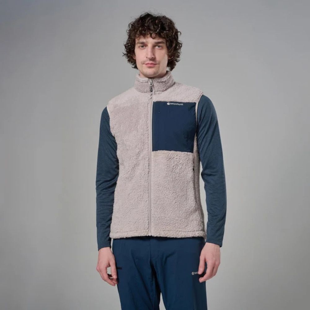 MKLPR_ECL_P_1_square_b214d799-76b2-4a64-a0ae-a2325d30818b_640x Man modeling a beige sherpa fleece vest with a navy chest pocket worn over a blue long-sleeve shirt and matching blue pants.
