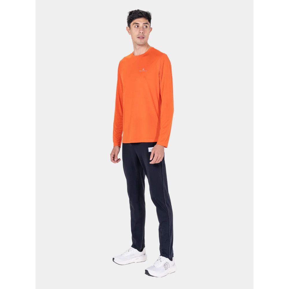 MKLPR_ECL_P_1_square_b214d799-76b2-4a64-a0ae-a2325d30818b_640x Male model wearing a bright orange long-sleeve athletic shirt with navy jogger-style pants and white sneakers, standing against a neutral backdrop.