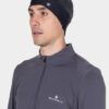RH-009061_Reflect_Beanie_R954_Black_Reflect-1078 Man wearing a dark knit beanie with a small logo and a gray Ronhill quarter-zip athletic top.